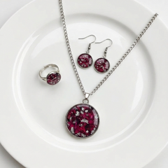 Jewelry set with pendant, ring, and earrings on a white plate