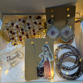Jewelry set including earrings and a necklace on a card with a decorative background.