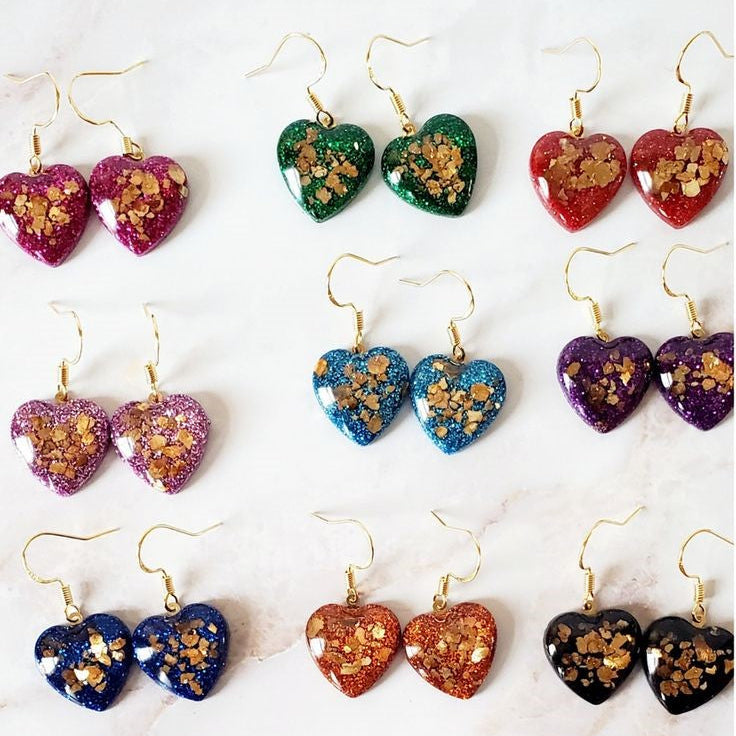 Heart-shaped earrings with colorful designs on a white background with text 'Jewelry that make a Statement!'.