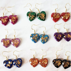 Heart-shaped earrings with colorful designs on a white background with text 'Jewelry that make a Statement!'.