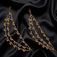 Pair of gold earrings on black satin fabric