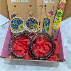 Earrings on Inci Aura cards with a colorful box and pen in the background