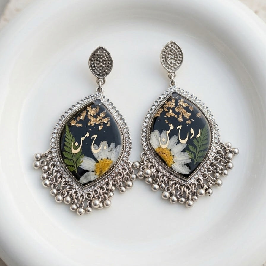 Decorative earrings with floral design on a white plate
