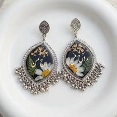 Decorative earrings with floral design on a white plate