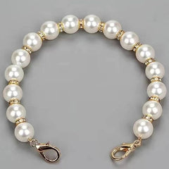 Pearl bracelet with gold accents on a gray background