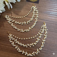 Pearl sahara with gold accents on a wooden surface with flowers and a brand tag.