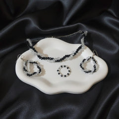 Set of jewelry including a necklace and earrings on a black satin background