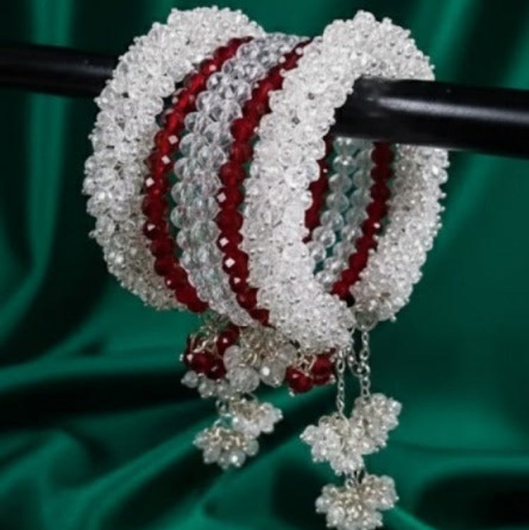 Decorative bangles with red and white pattern on a green fabric background