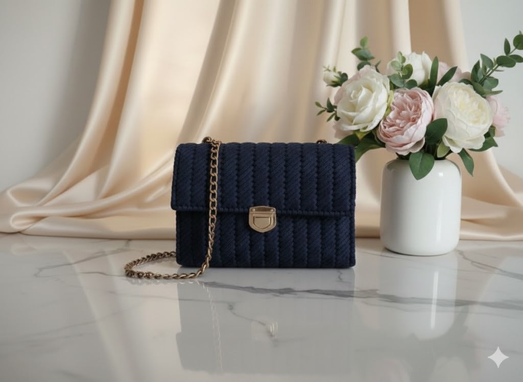 Navy blue knitted handbag with a gold chain.