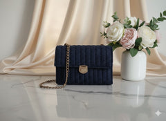 Navy blue knitted handbag with a gold chain.