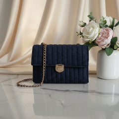 Navy blue knitted handbag with a gold chain.