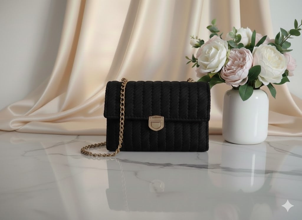 Black quilted handbag with a gold chain.