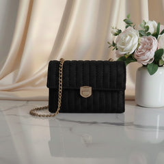 Black quilted handbag with a gold chain.