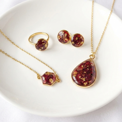 Jewelry set with red teardrop-shaped stones on a white plate