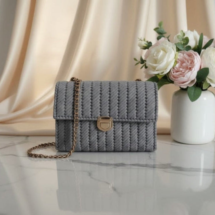 Gray woven handbag with a gold chain.
