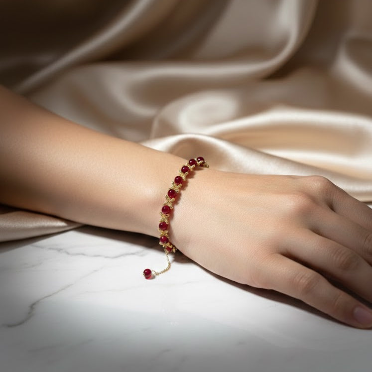 Hand wearing a red beaded bracelet 