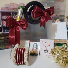 Decorative items including a black circular object with red ribbons, a bottle, and jewelry on a table.