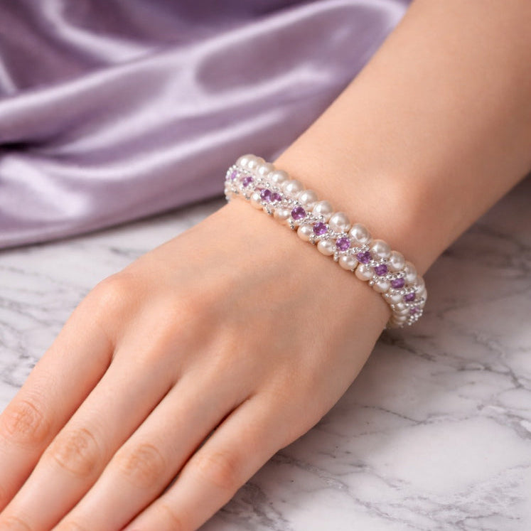 Hand wearing a bracelet with purple stones 