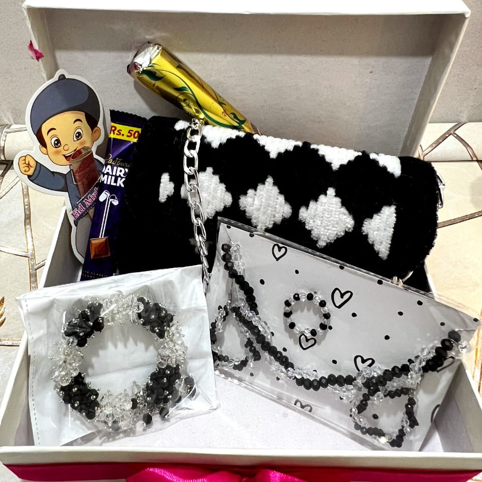 Black and white patterned clutch bag with a bracelet on a white surface