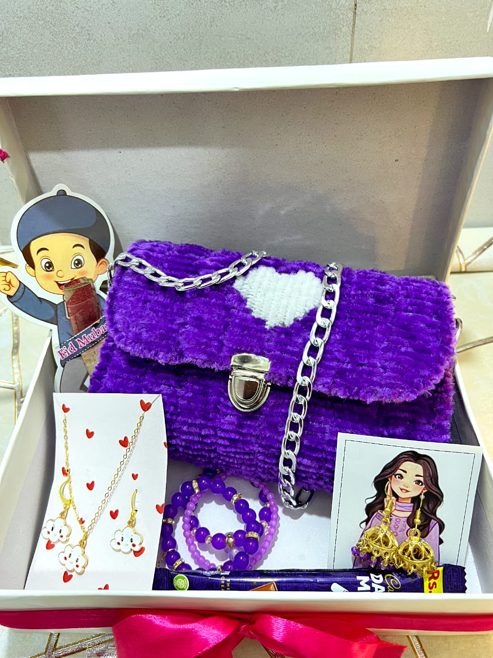 Purple fluffy handbag with accessories and cards in a box