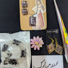 Jewelry set with earrings and a brooch on a black surface