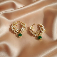 Pair of gold hoop earrings with pearl-like beads and green gemstones 