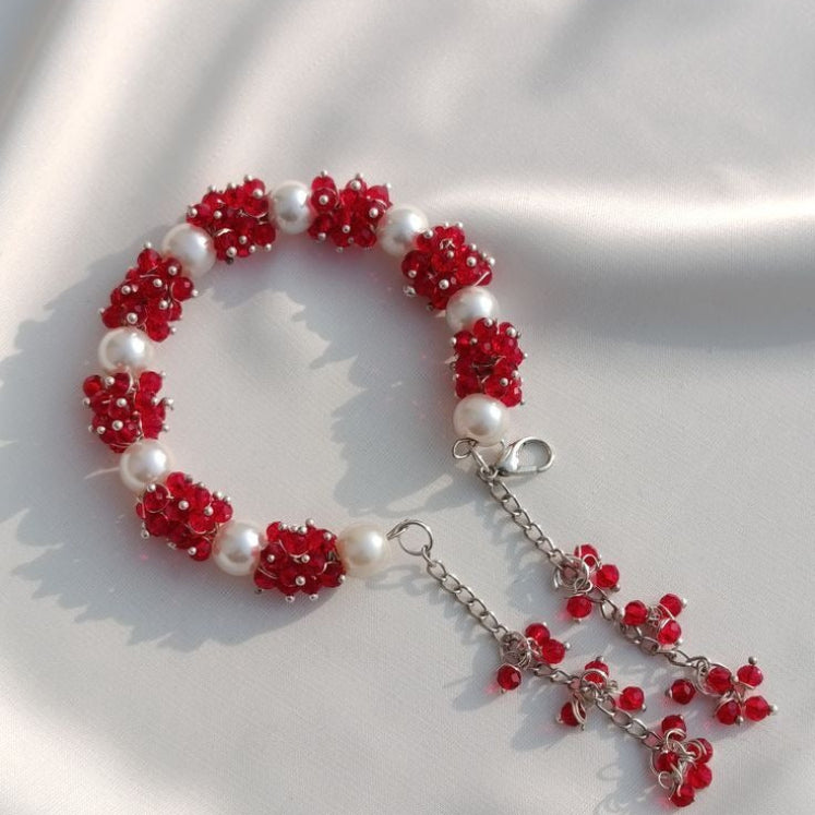 Bracelet with red floral beads and a silver chain 