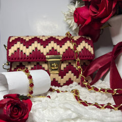 Red and gold handbag with floral decorations on a white background