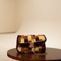 Checkered handbag on a round wooden table with a neutral background