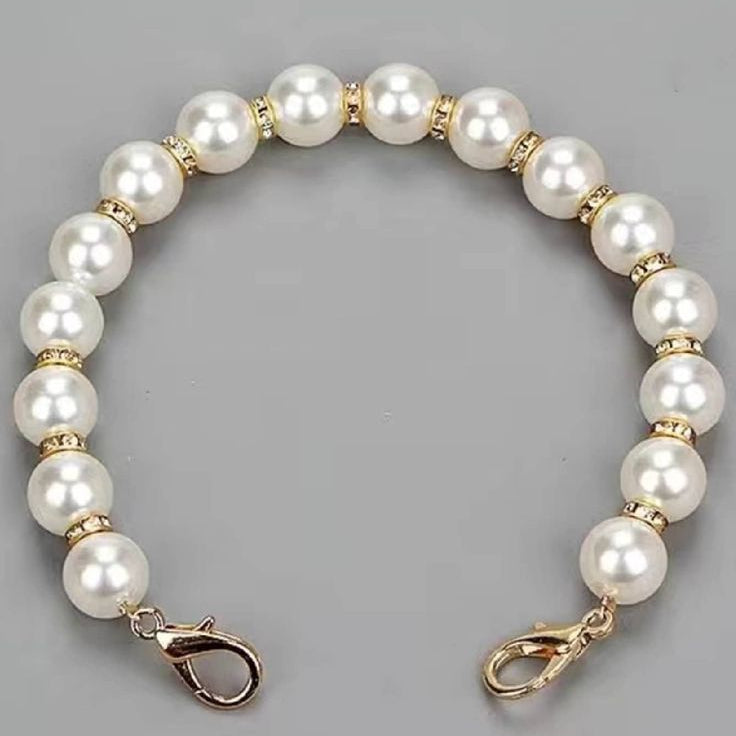 Pearl bracelet with gold accents on a gray background