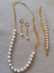 Pearl necklace and earrings on a light gray surface