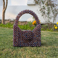 Decorative handbag with colorful beads on grass