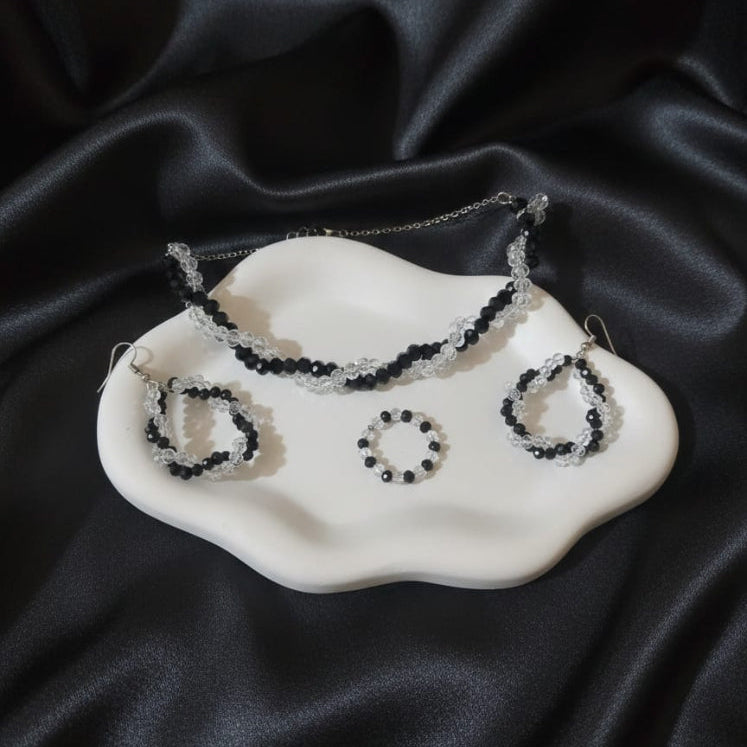 Set of jewelry including a necklace and earrings on a black satin background